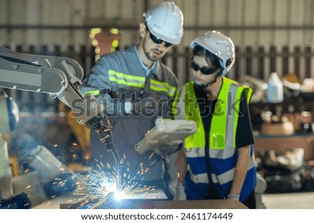 Engineer control robot arm machine welding steel, worker using forcing welding control screen which for precision welding control. Worker control automation welding robot in hi tech heavy factory