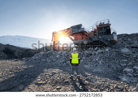 Engineer Control work of excavator. Coal mine workers in an open pit, back view.