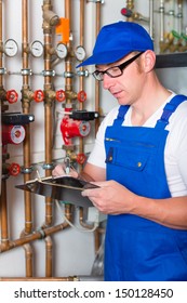 Engineer Controlling The Heating Pipes At The Boiler Room