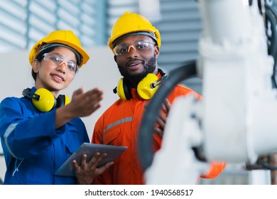 engineer cooperation male and female technician maintenance control relay robot arm system welding with tablet laptop to control quality operate process work heavy industry 4.0 manufacturing factory - Powered by Shutterstock