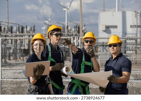 Engineer coordinating operations at an energy facility with wind turbines, highlighting teamwork, technical planning, safety and the development of clean and sustainable renewable power solutions.