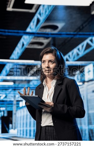 Engineer in data center helping users, speaking into headset mic, managing support tickets. IT expert working in server farm providing remote assistance to b2b enterprise clients