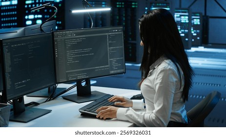 Engineer in data center sitting down at desk, installing software on computer, troubleshooting issues. Woman arriving at work in server hub, establishing performance benchmarks, camera A