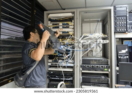 The engineer in a data processing center of ISP Internet Service Provider hold fiber patch cords