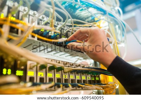 The engineer in a data processing center of ISP Internet Service Provider hold fiber patch cords
