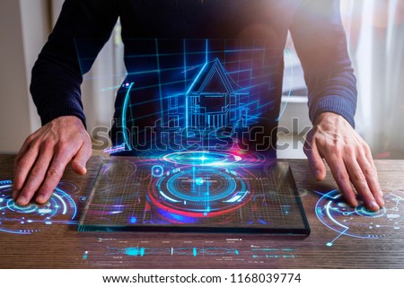 An engineer designs a high-energy house using sophisticated and futuristic programs with holography. Concept of: home, future, project and augmented reality.