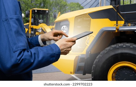 Engineer with a digital tablet on the background of construction machines