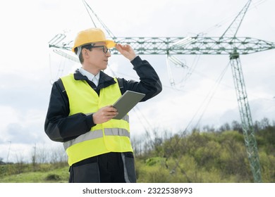 Engineer with digital tablet on a background of power line tower	