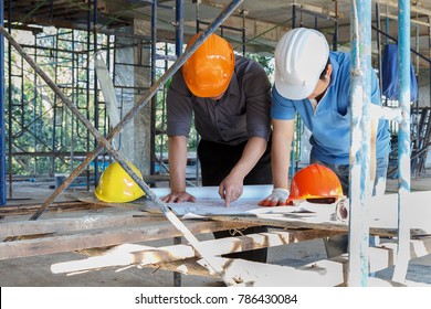 Engineer discussing with foreman about project in building construction site