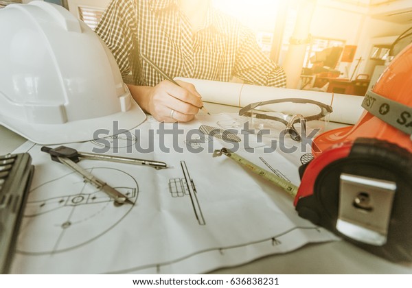engineer discussing at the table with blueprint -\
Closeup on hands and project print,selective focus,Business concept\
vintage color