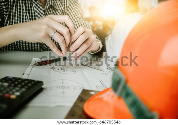 engineer discussing at the table with blueprint -\
Closeup on hands and project print,selective focus,Business concept\
vintage color