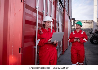 Engineer or dockworker working in the construction container dock yard checking and inspection containers data on program environment is container shipping Logistics business concept.