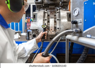 Engineer Doing Maintenance On A Injection Mold For Plastic Components, Industrial And Automotive Concept