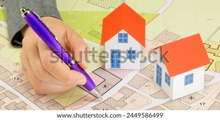 Engineer drawing over an imaginary cadastral map of territory and General Urban Planning with buildings, roads and land parcel - Building activity concept 