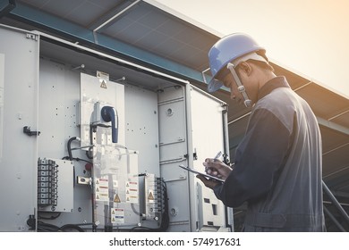 Engineer Or Electrician Working On Checking And Inspect Equipment With Checklist At Outdoor Industry 