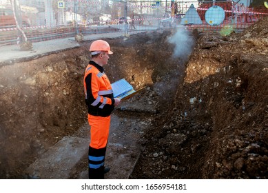 engineer examines the damaged section of the heating main, repair of the heating main