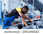 Engineer expertly examines car distributor using advanced mechanical tools, ensuring optimal automotive performance and safety. Qualified garage employee conducts annual vehicle checkup