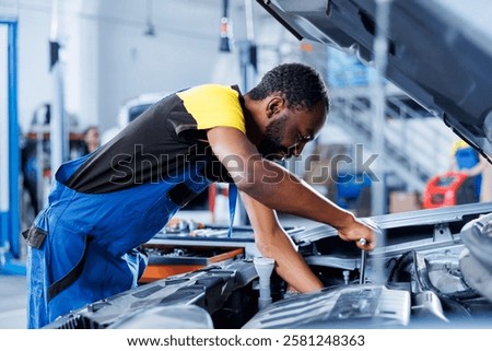 Engineer expertly examines car distributor using advanced mechanical tools, ensuring optimal automotive performance and safety. Qualified garage employee conducts annual vehicle checkup