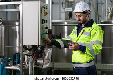 Engineer Or Factory Worker Using Tablet Computer For Finding How To Use Machine Control Panel In Factory