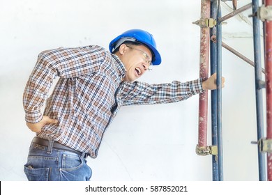 Engineer Feeling Pain From His Back Injury From Workplace During Working At Construction Site. Worker Risking From Accident When Working In Building Renovation Without Compensation. Engineer Concept 