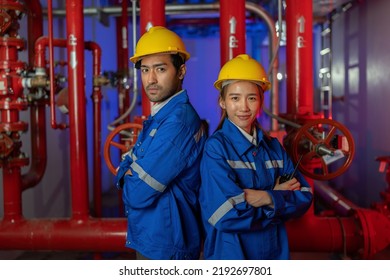 An Engineer In The Fire Protection Pump Room Standing Smile Portrait Near Spray Nozzle Head Valve At The Red Pipeline
