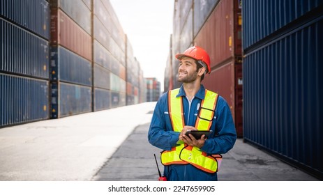 Engineer or foreman checking inventory or task details at container yard warehouse while wearing PPE and holding tablet., Logistics concept inside the shipping, import, and export industries. - Shutterstock ID 2247659905