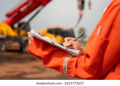 An engineer or foreman is checking on safety checklist form of lifting crane at the drilling rig work site. Industrial safe working concent, close-up and selective focus.
