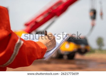An engineer or foreman is checking on safety checklist form of lifting crane at the drilling rig work site. Industrial safe working concent, close-up and selective focus.