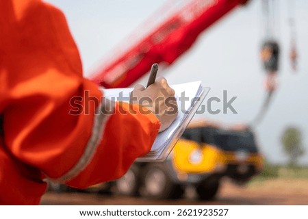 An engineer or foreman is checking on safety checklist form of lifting crane at the drilling rig work site. Industrial safe working concent, close-up and selective focus.