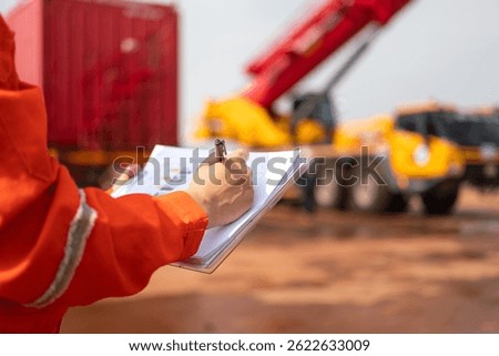 An engineer or foreman is checking on safety checklist form of lifting crane at the drilling rig work site. Industrial safe working concent, close-up and selective focus.