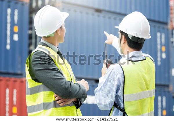 Engineer and foreman use radio\
communication for Warehouse shipping transportation\
concept.