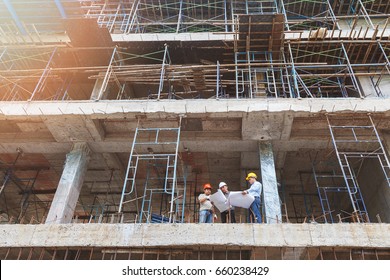 Engineer, Foreman And Worker Discussing In Building Construction Site