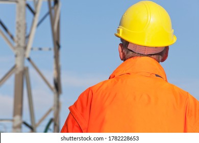 Engineer, Foreman Or Worker With Hard Hat And Protective Clothing In Front Of  Industrial Background - Copy Space On The Orange Jacket