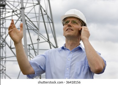 Engineer Gesturing While Talking On Cell Phone On Construction Side