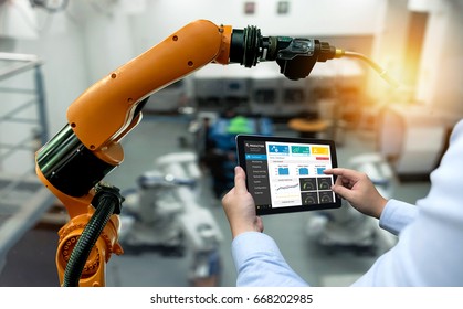Ingenieurhandmaschine mit Tablet-Roboterarmmaschine, schwere Automatisierung in intelligenter Industrie mit Tabletts-Echtzeit-Monitoring-System-Anwendung. Industrie-4.