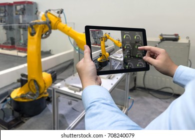 Engineer Hand Using Tablet, Heavy Automation Robot Arm Machine In Smart Factory Industrial With Tablet Real Time Monitoring System Application. Industry 4th Iot Concept.