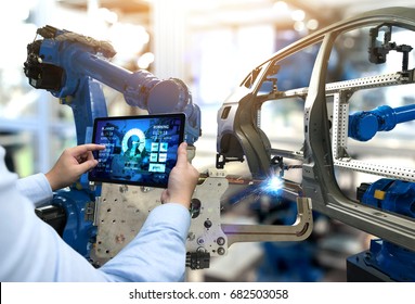 Programmieren Sie Tablet mit der Software für die Echtzeit-Überwachung. Automation Roboterarmmaschine in der intelligenten Automobilindustrie 4th iot , digitale Fertigungsoperation.