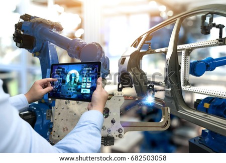 Engineer hand using tablet with machine real time monitoring system software. Automation robot arm machine in smart factory automotive industrial Industry 4th iot , digital manufacturing operation.