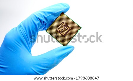 Engineer hand wearing blue rubber gloves holding chipset cpu,the concept of computer, service, electronics, hardware, repairing, upgrade and technology.