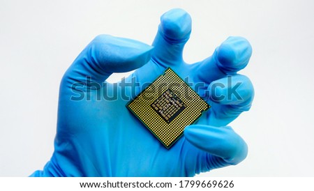 Engineer hand wearing blue rubber gloves holding chipset cpu,the concept of computer, service, electronics, hardware, repairing, upgrade and technology.