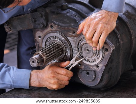 Engineer hands fixing engine power transmission gears box
