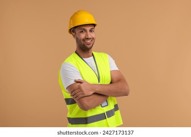 Engineer with hard hat and badge on beige background - Powered by Shutterstock