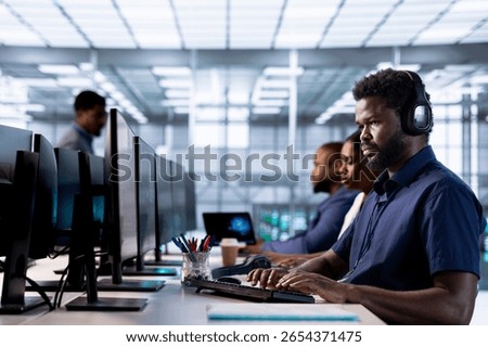 Engineer hearing podcasts to make time pass faster while working in server farm to optimize it for data processing requirements. IT expert listens songs and ensures data center operates efficiently