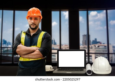 Engineer In Helmet For Workers Security On Modern Office Buildings And Management On The Construction Drawing Plan Near Laptop Working In Engineering Tools On Desk
