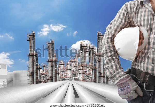 Engineer and helmet for working at\
petrochemical oil refinery against beautiful sky\
