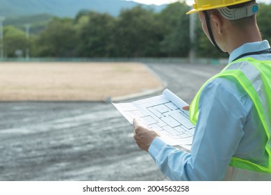 Engineer Holding Blueprints To Review Construction Drawings