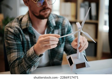 Engineer holding model of plastic wind turbine