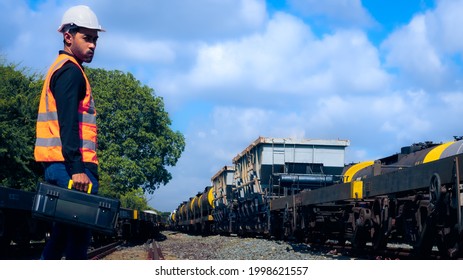 Engineer holding the tool box to start his daily work, engineer observation the freight train stone.