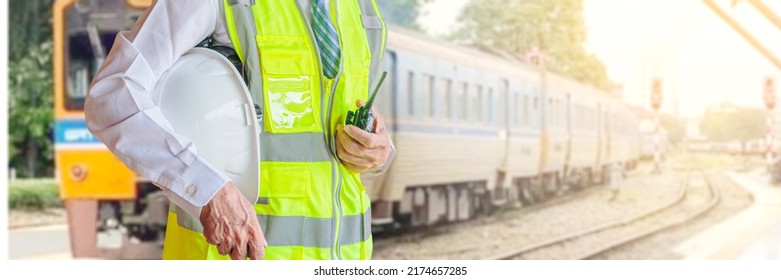 Engineer Holding White Hat And Radio For The Safety Of Working With The Train Station Background