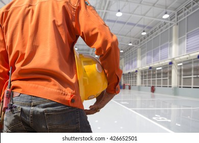 Engineer Holding Yellow Helmet For Workers Security On Indoor Factory Epoxy Floor Construction Site Background